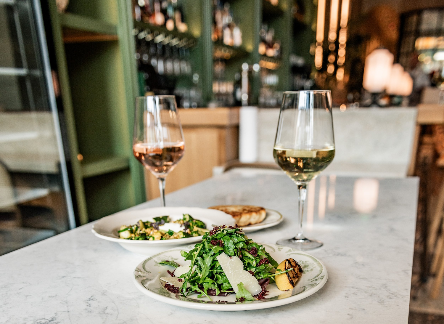 Salads and wine glasses on a table