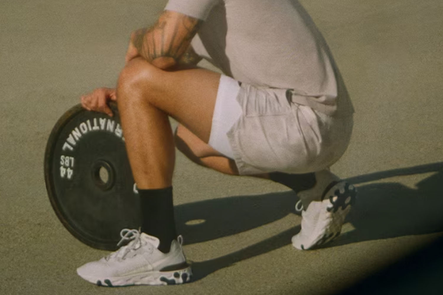 a model in YPB next to a barbell