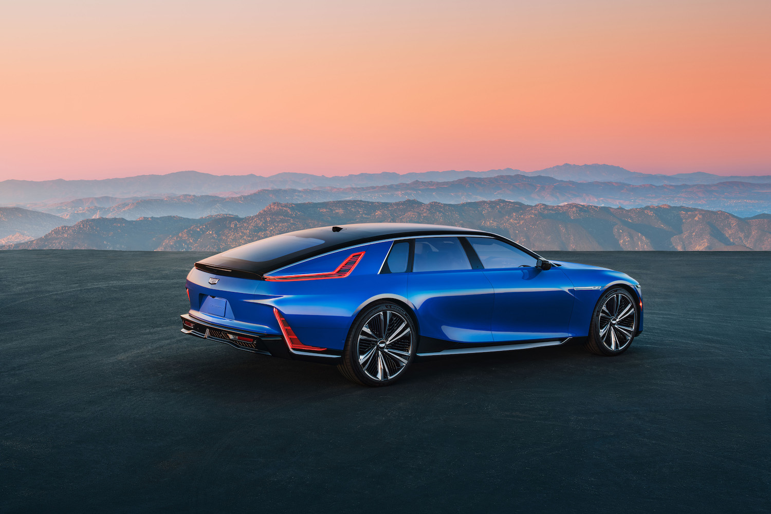 Rear 3/4 view of Cadillac CELESTIQ on a plateau overlooking mountains in the background.