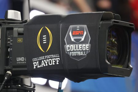 A TV camera with ESPN's college football playoff logos.