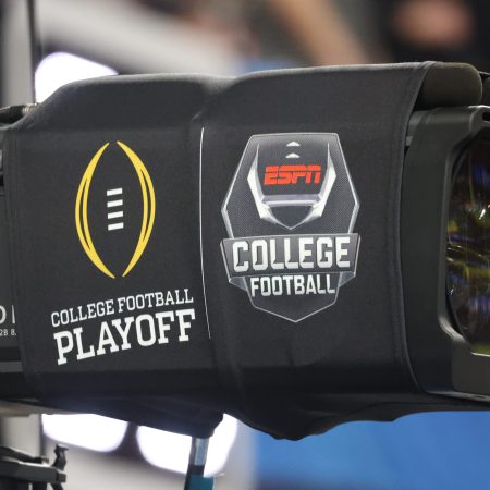 A TV camera with ESPN's college football playoff logos.