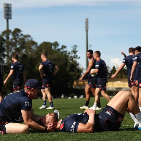 A rugby player getting his neck massaged.