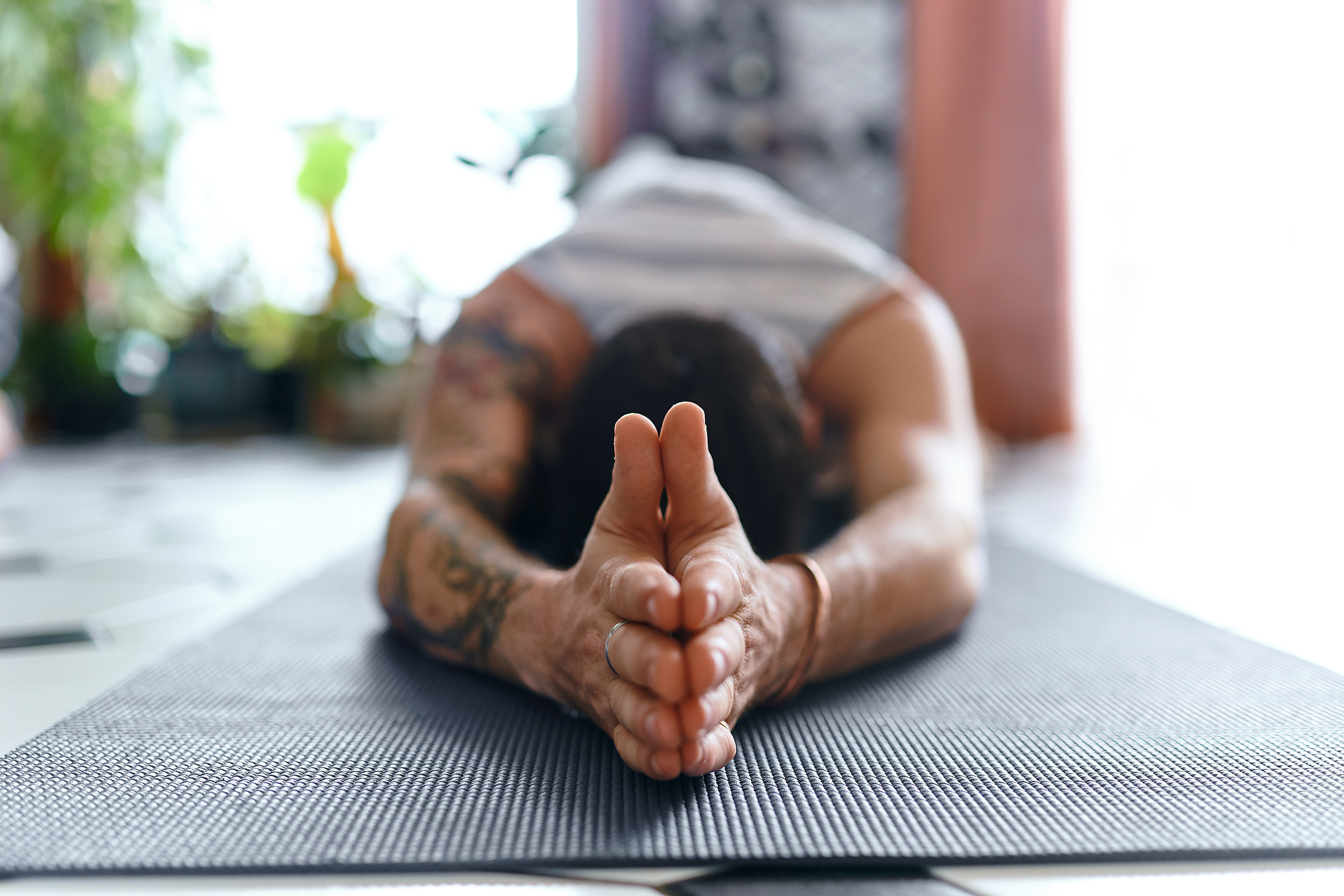 A man practicing mat Pilates in order to elongate his spine.