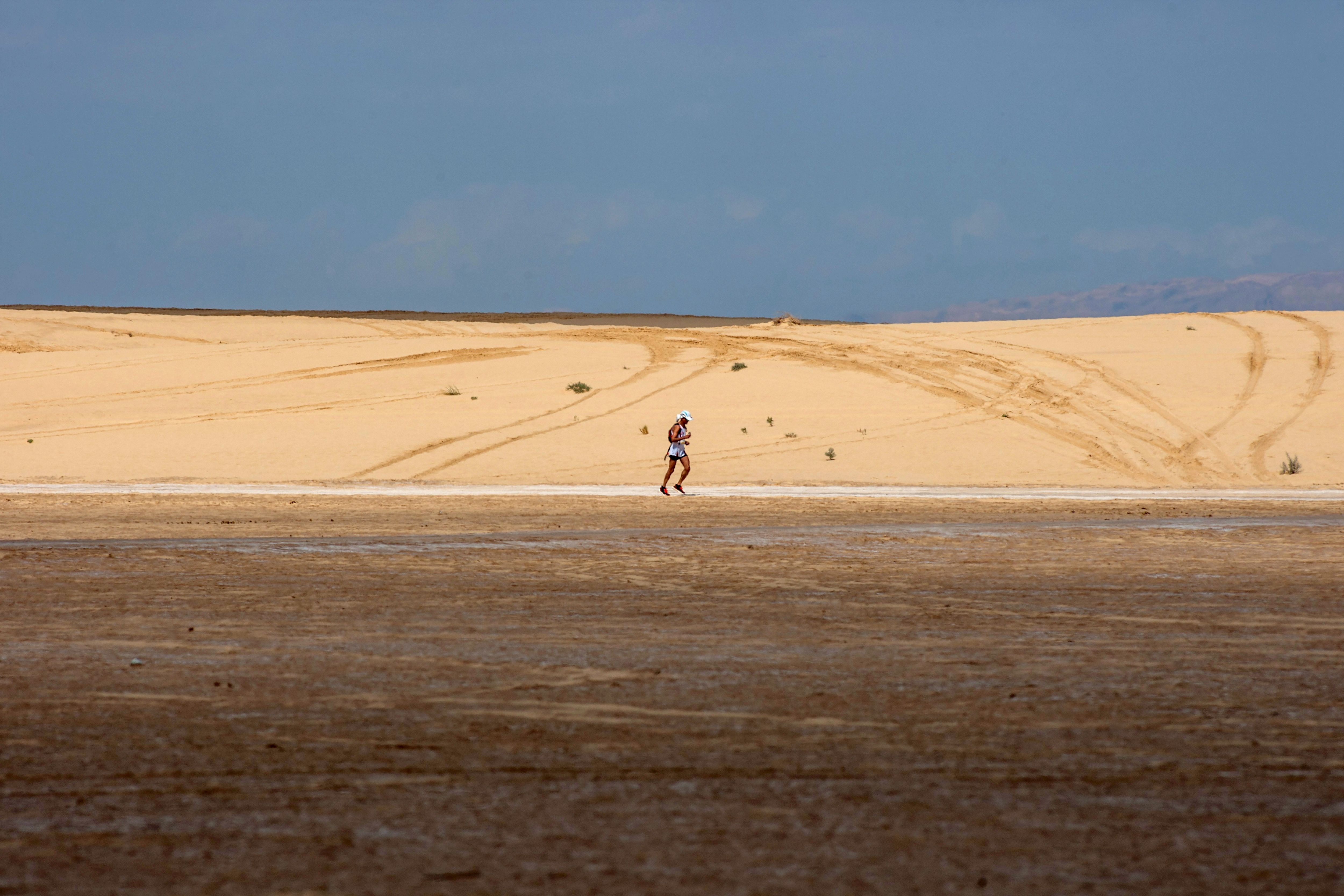 A man running across a desert in Tunisia.