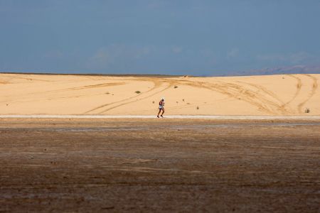 A man running across a desert in Tunisia.