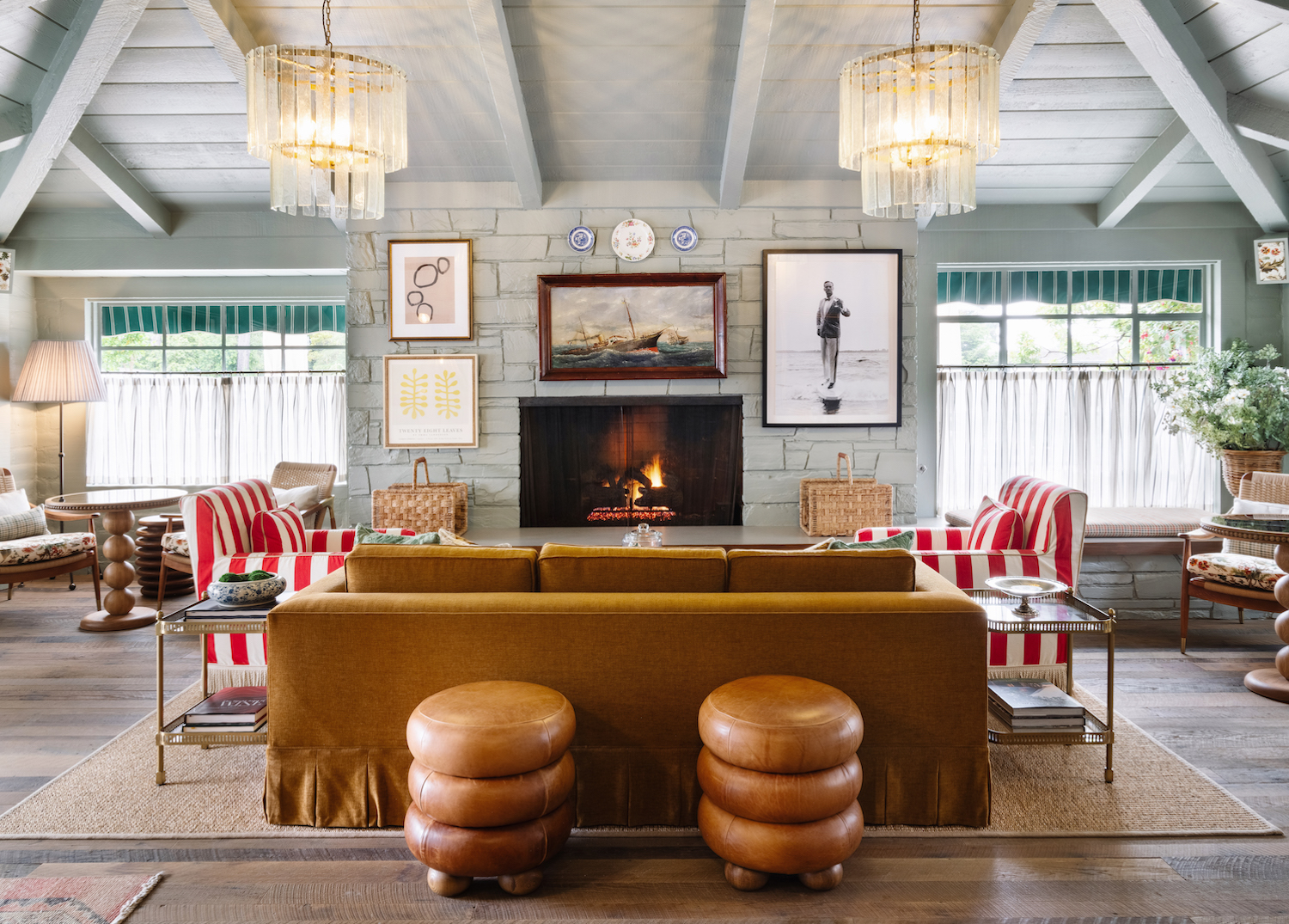 Brown leather and red-and-white-striped couches in a gray-colored room with blue accents and nautical-themed decor