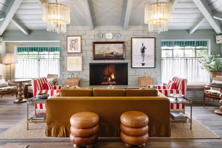Brown leather and red-and-white-striped couches in a gray-colored room with blue accents and nautical-themed decor