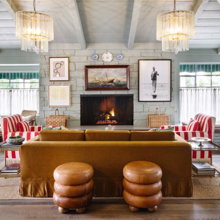 Brown leather and red-and-white-striped couches in a gray-colored room with blue accents and nautical-themed decor