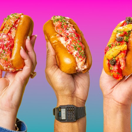 Three lobster rolls being held up in the air