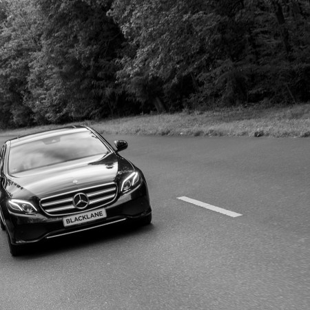 B&W photo of a car driving on a street
