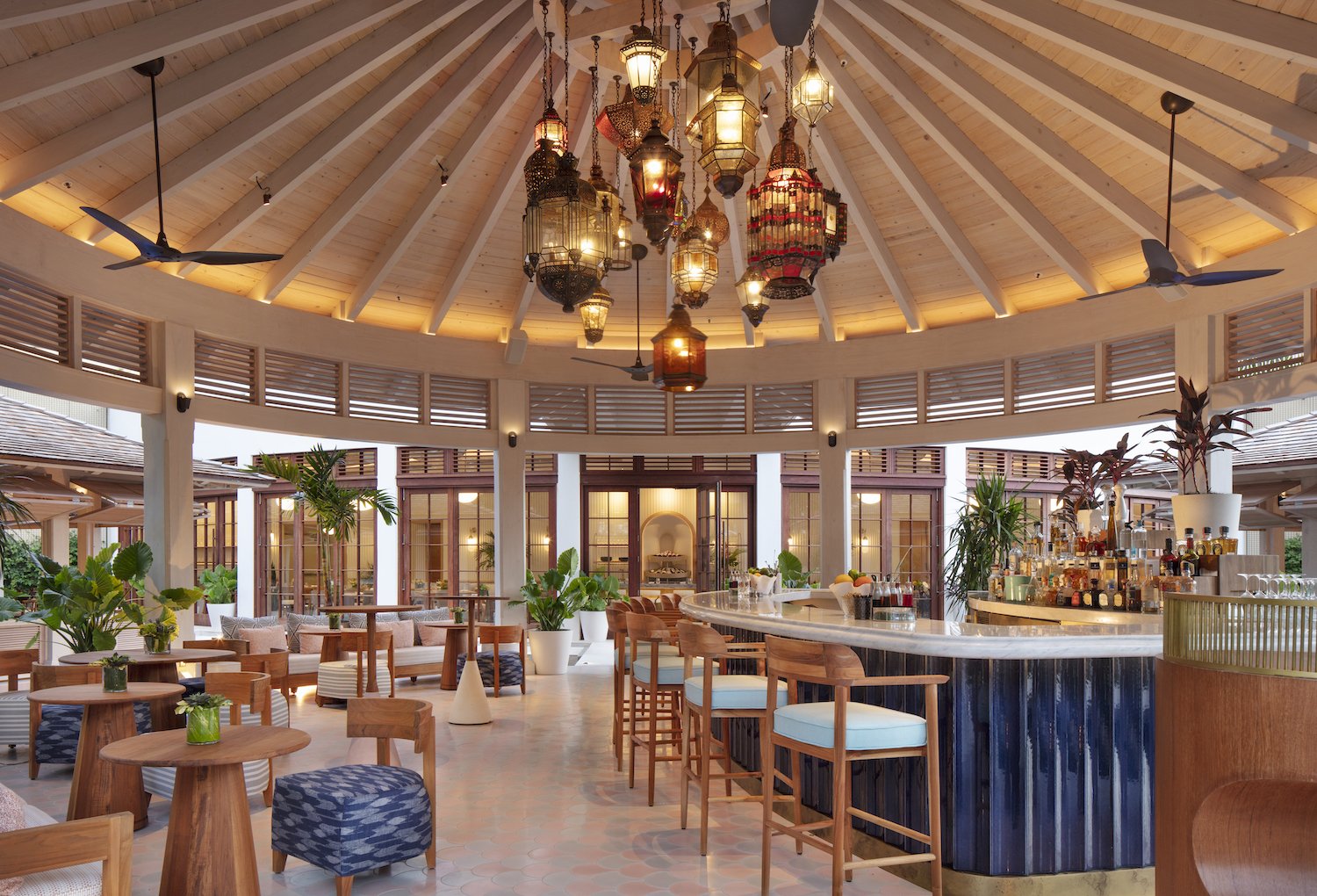 Outdoor bar under a pavillion with a bar, barstools and large chandelier 