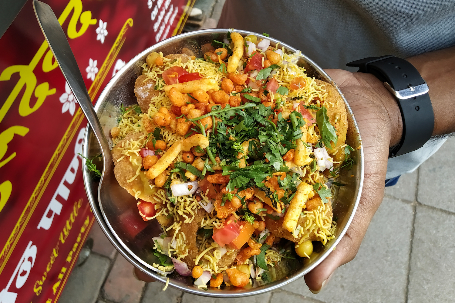 Holding Indian street food masala chaat sev puri dish
