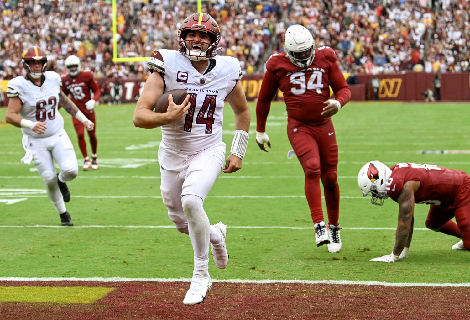 Washington Commanders quarterback Sam Howell (14) runs six yards into the end zone for the go ahead touchdown during the fourth quarter of the game against the Arizona Cardinals at FedEx field on September 10, 2023.