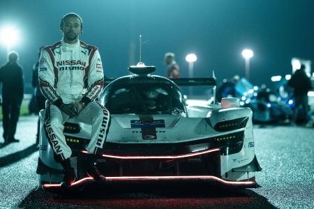 A picture of Jann Mardenborough sitting against his racecar.