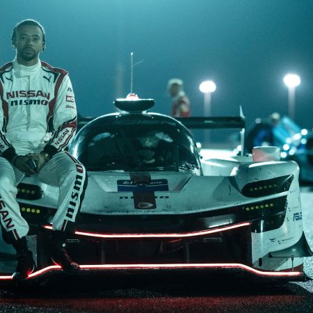 A picture of Jann Mardenborough sitting against his racecar.