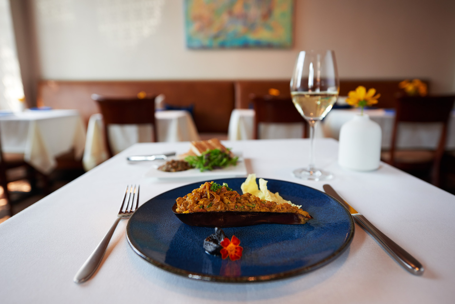 Pie slice on a blue plate at a white table
