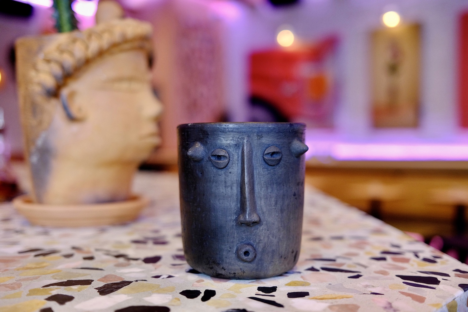 Mole Negroni in a face mug on a terrazzo bar top