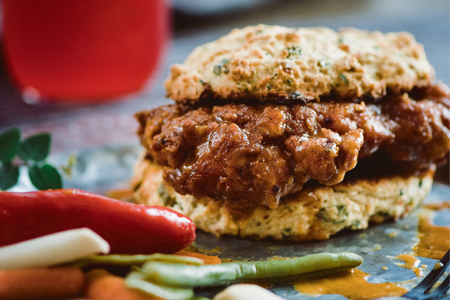a glazed piece of fried chicken on a biscuit