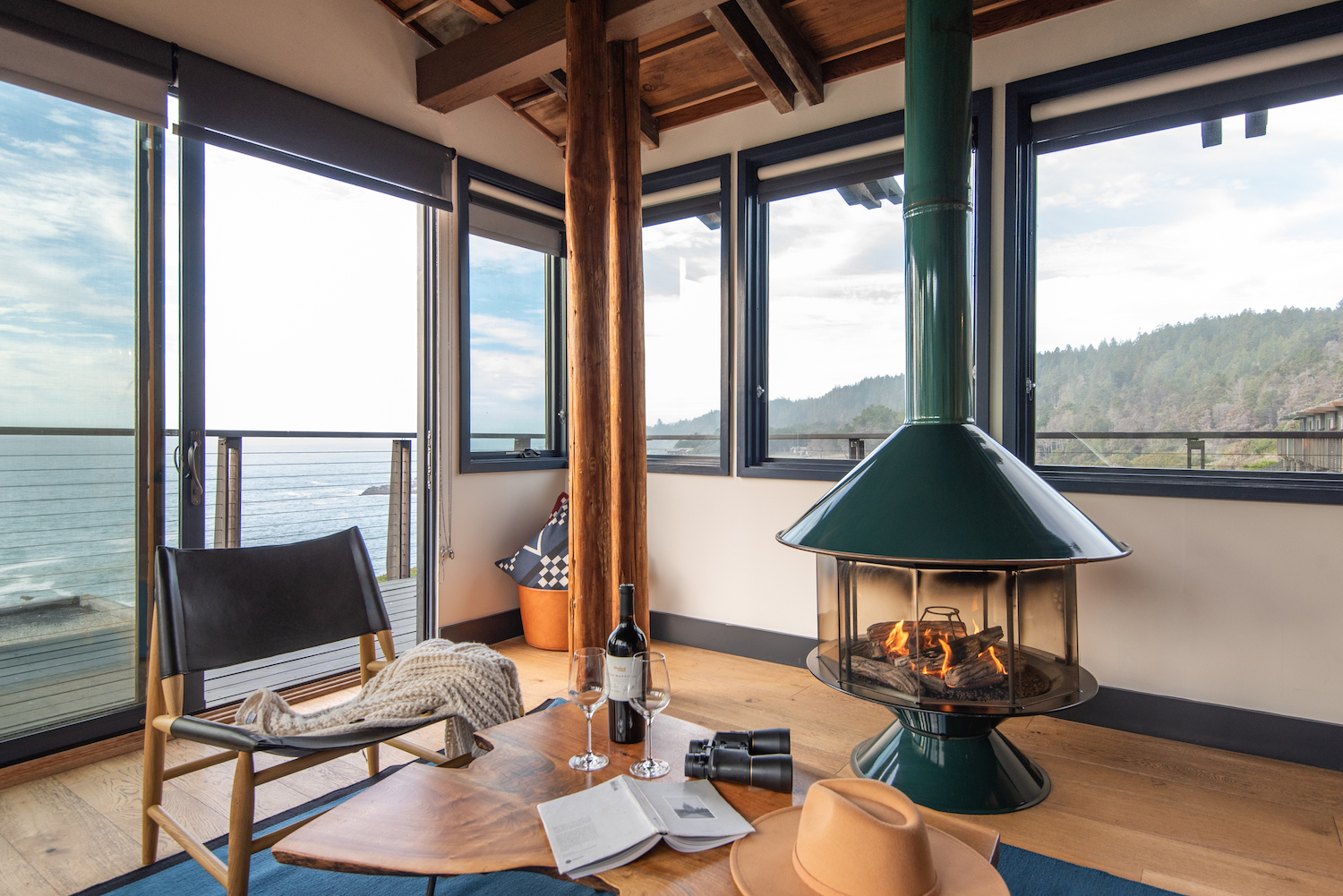 Sitting area with a fire overlooking hill and ocean landscape