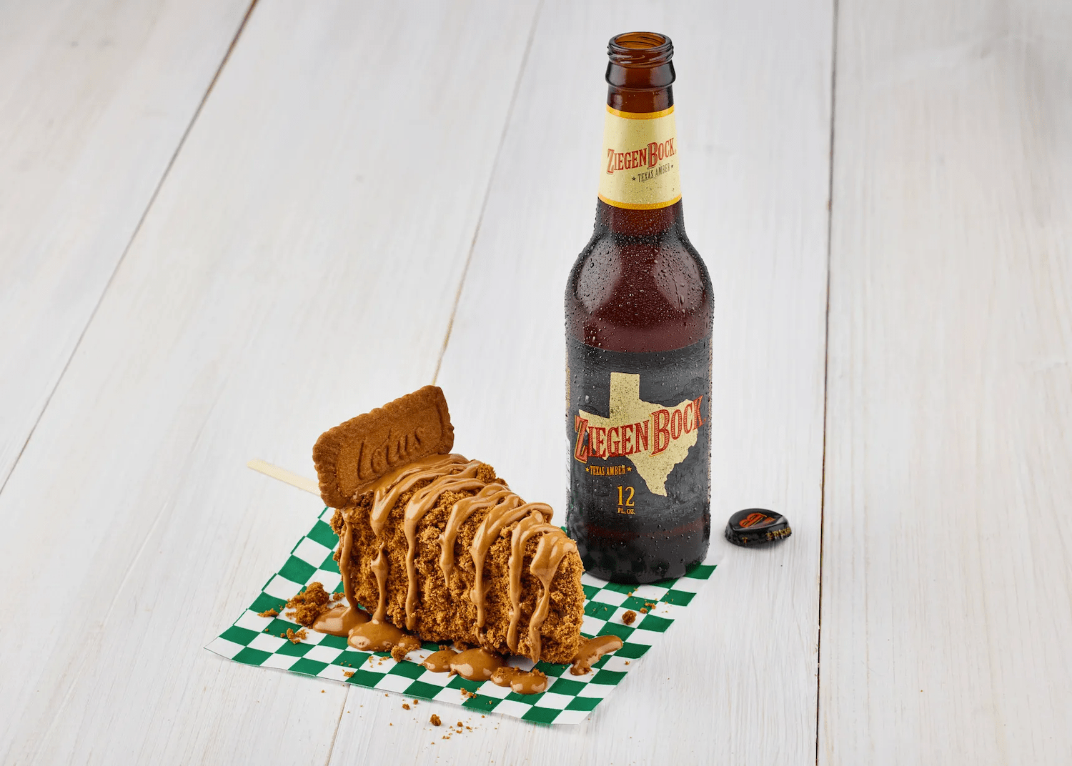 Slice of pie with a Biscoff cookie next to a beer bottle