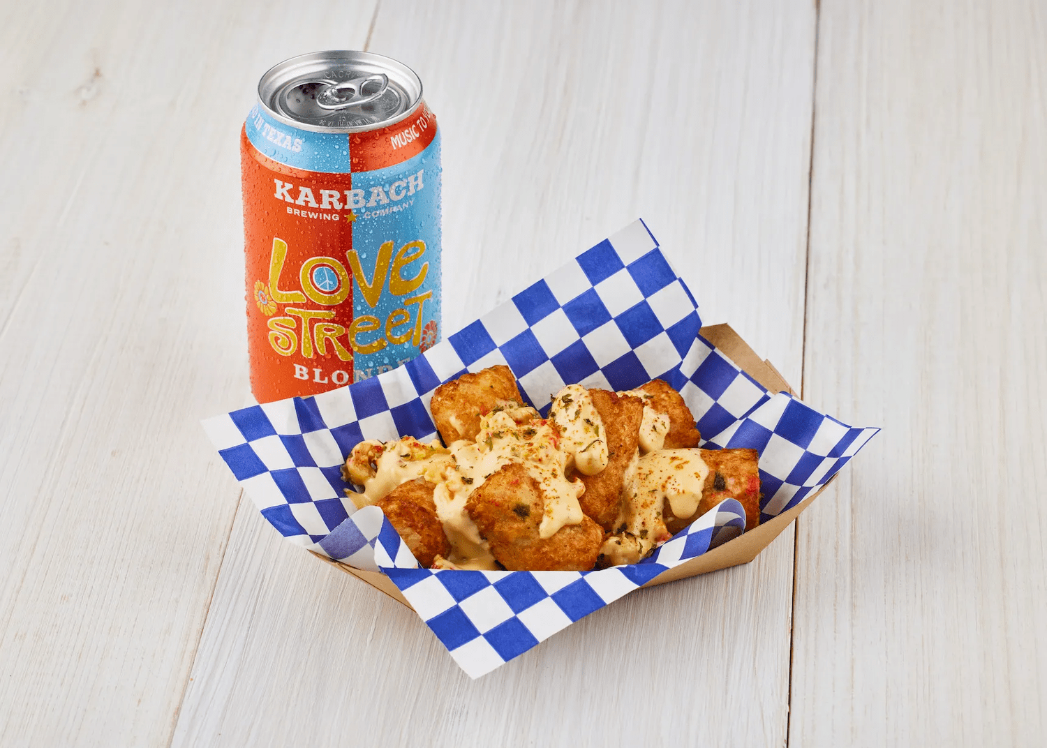 Cheesy crab tater bites next to a can of beer