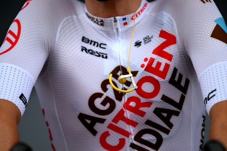 A close-up of a cyclist's chest with headphones dangling.