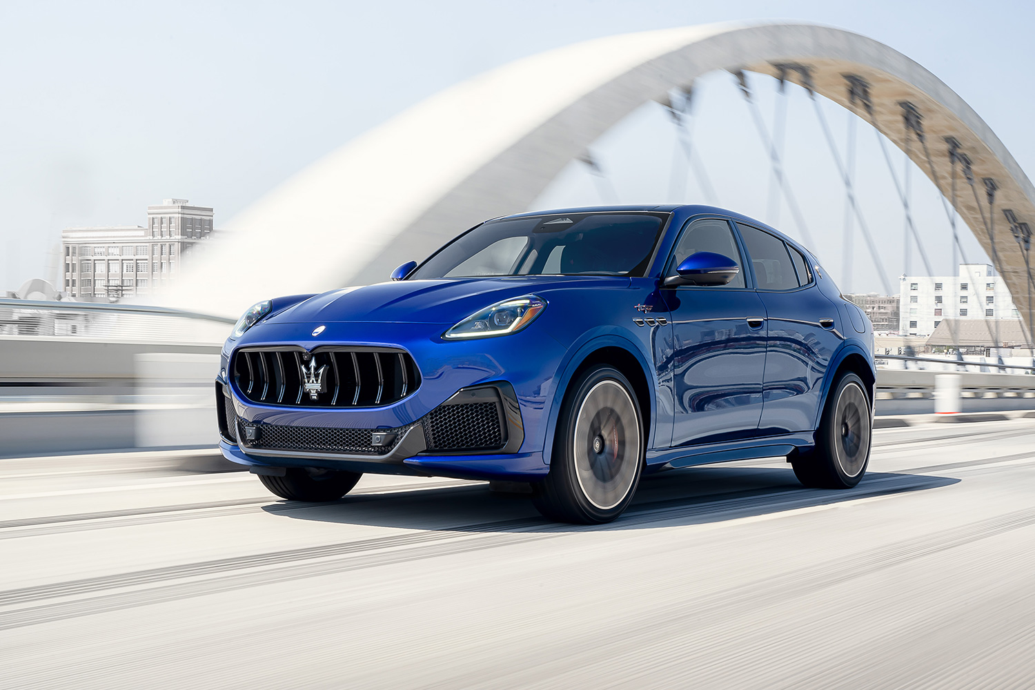 A blue 2023 Maserati Grecale Trofeo SUV driving across a bridge