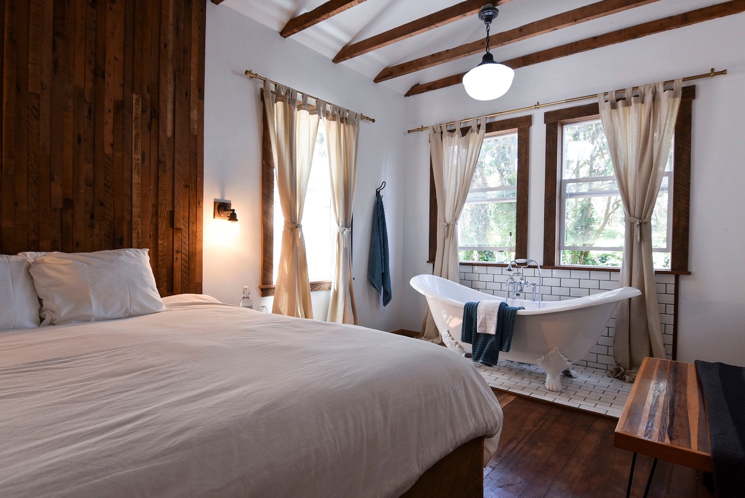 Room with bedding, large tub and scenic view