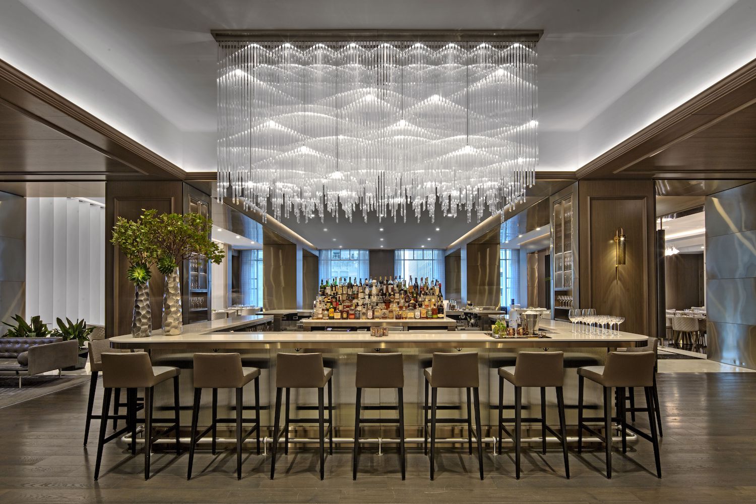 Bar area with silver and brown decor and large chandelier