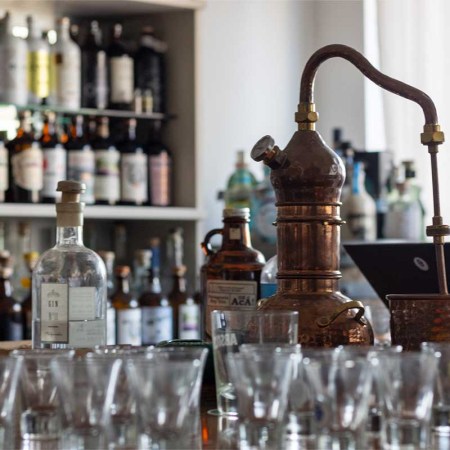 A shop filled with a still and bottles of Argentine gin