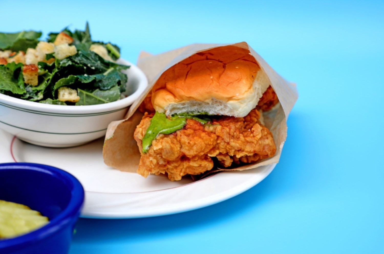 Fried chicken sandwich next to a salad