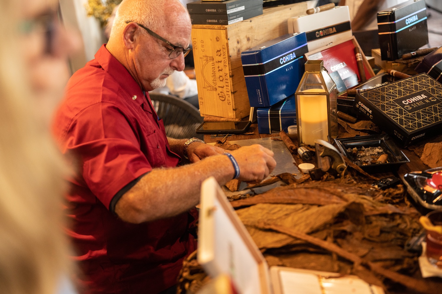 Man sitting at a stand rolling cigars