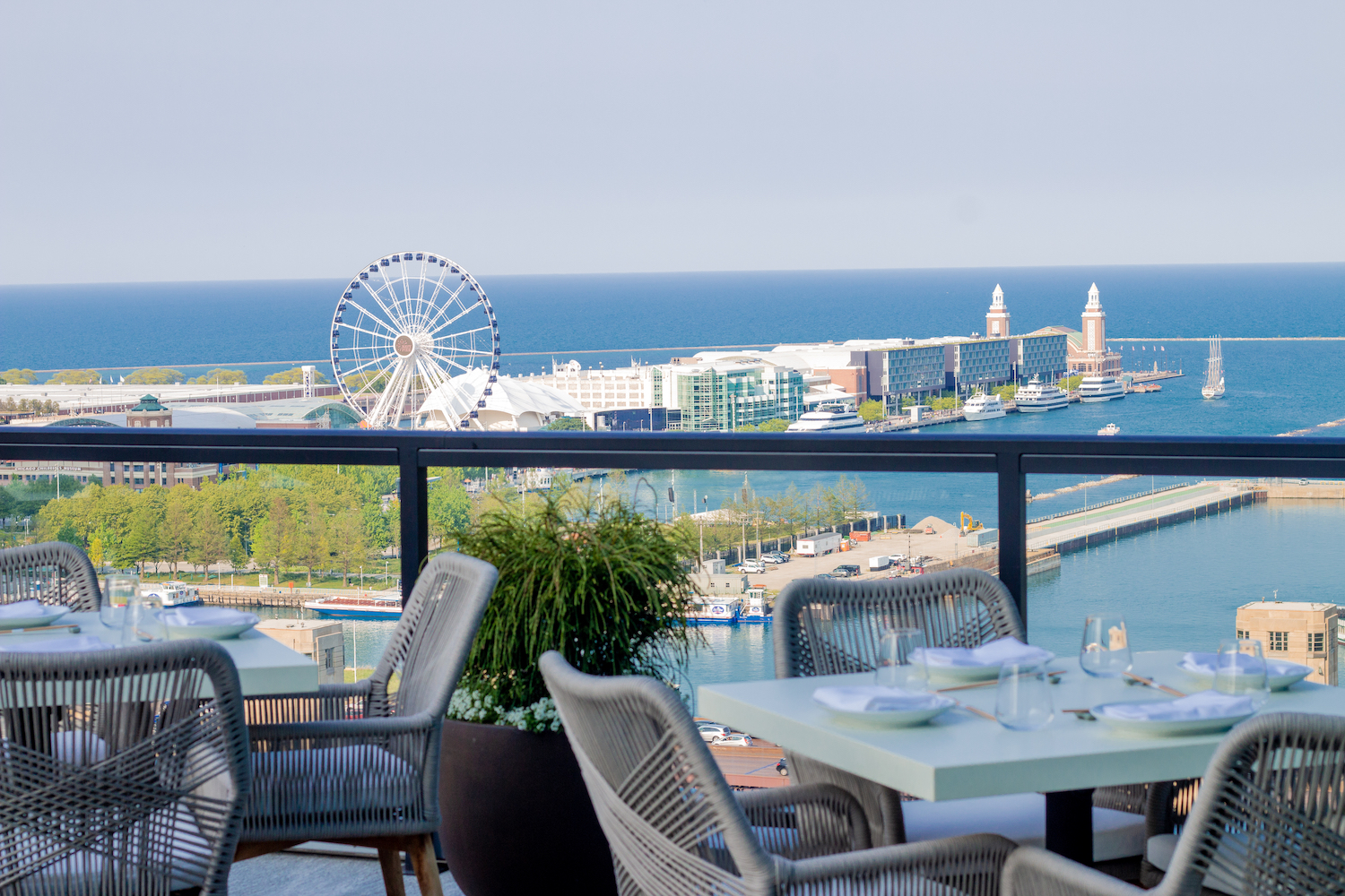 Tables on a patio overlooking water and beach