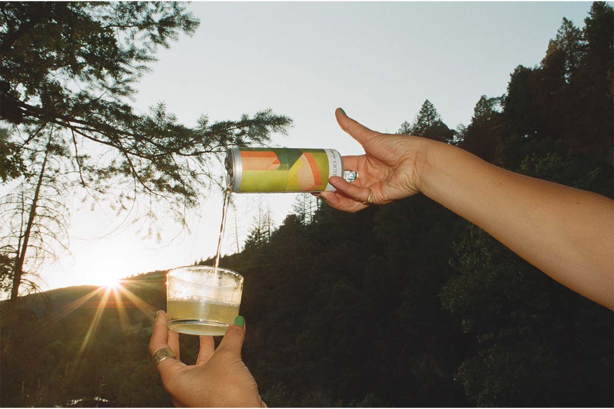 Nomadica Sparkling White being poured into a short glass in the forest