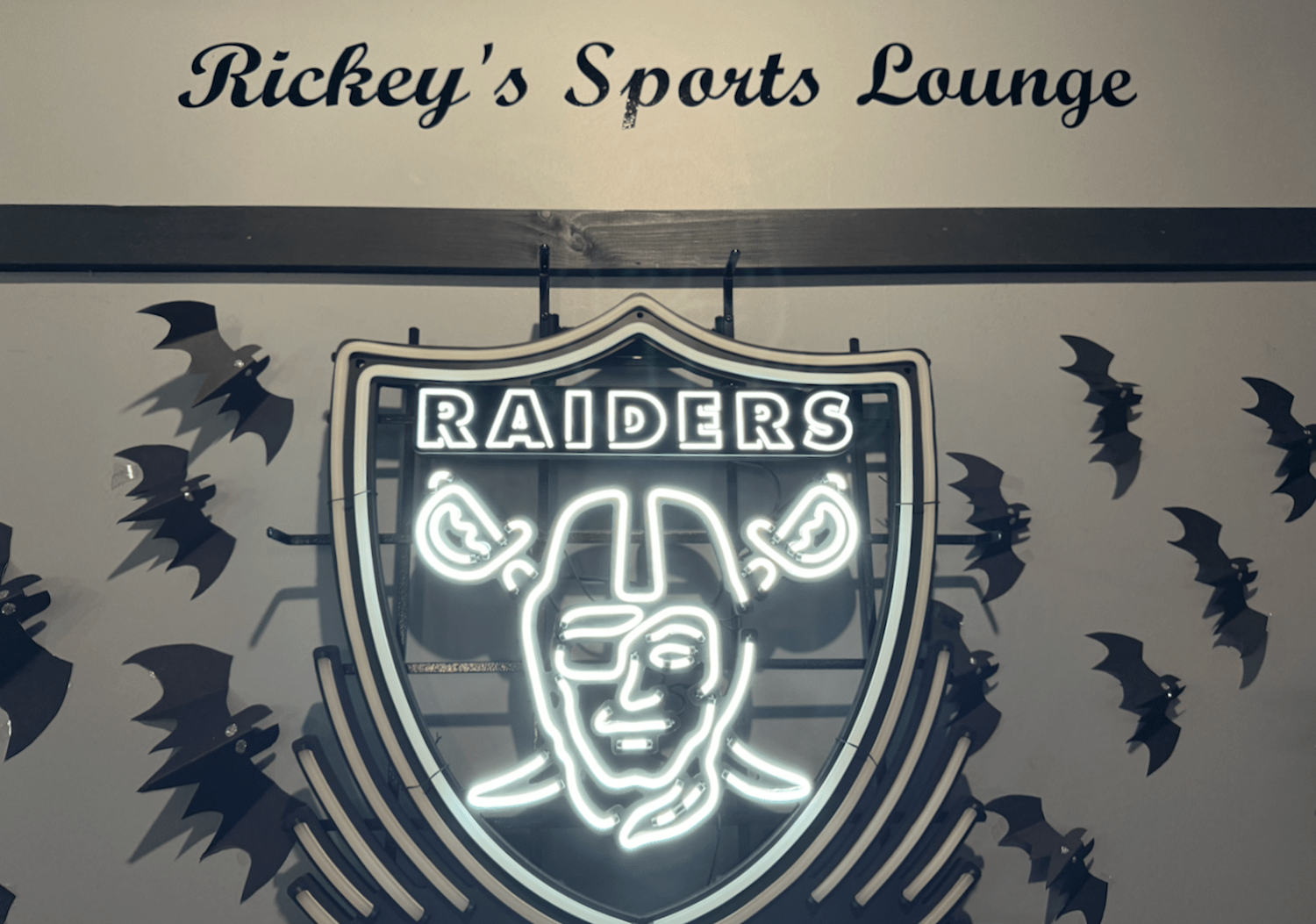 Neon Raiders sign under RIckey's logo