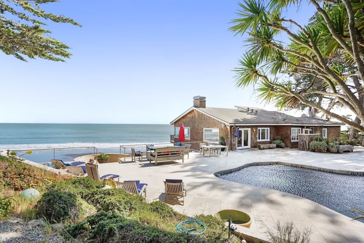 Small brown house with a pool facing the beach