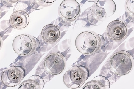 a crowded table of empty white wine glasses