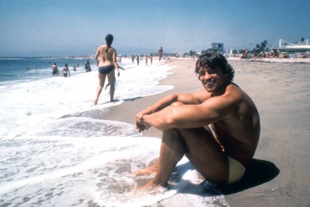 Arnold Schwarzenegger sitting on the beach, in his 20s, grinning. We look at the life lessons in his new book, "Be Useful"