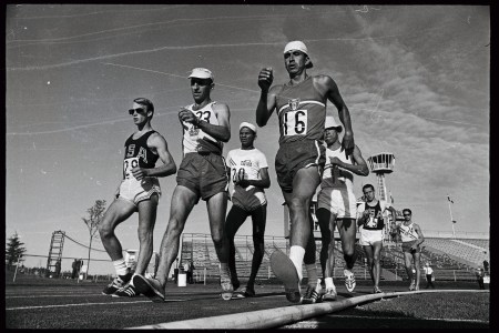A group of runners in singlets walking. Black and white photo.