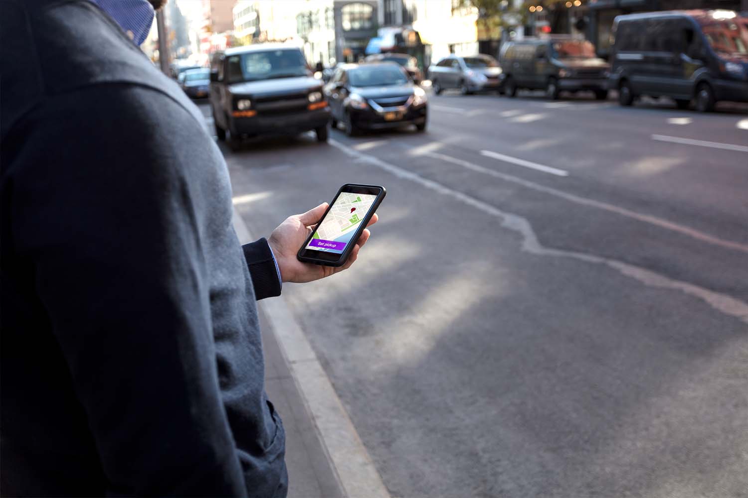 A person using the rideshare app Lyft. Lyft now says they will pay passengers in Lyft credits if drivers are late to scheduled pickups.