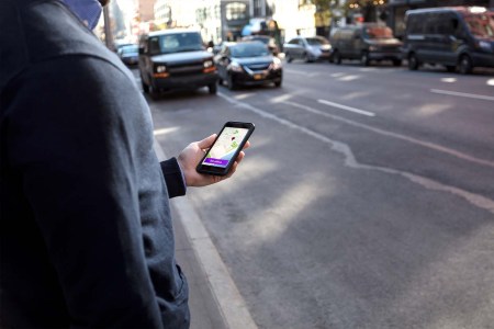A person using the rideshare app Lyft. Lyft now says they will pay passengers in Lyft credits if drivers are late to scheduled pickups.