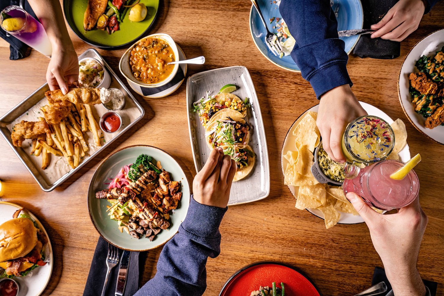 Spread of food including tacos, fish and chips, burgers and chips and dip