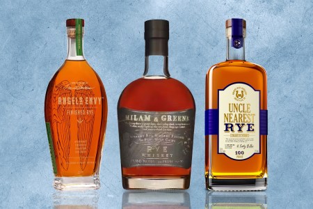 lineup of three bottles of rye whiskey on a blue textured background