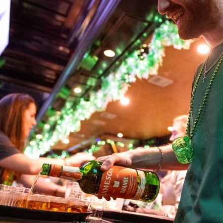 A waiter pours shots of whiskey at the Playwright Irish Pub near Times Square after the St. Patrick’s Day parade on March 17, 2022 in New York City. Irish whiskey brands are trying to figure out how to spread the word about their whiskey on days outside of March 17.
