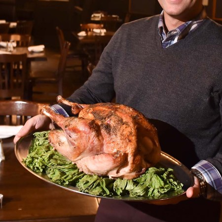 Hitching Post co-owner George Zeppos poses for a photo with one of the turkeys that his restaurant has prepared in advance of Thanksgiving. At The Hitching Post restaurant in Bern Township Tuesday evening November 21, 2017