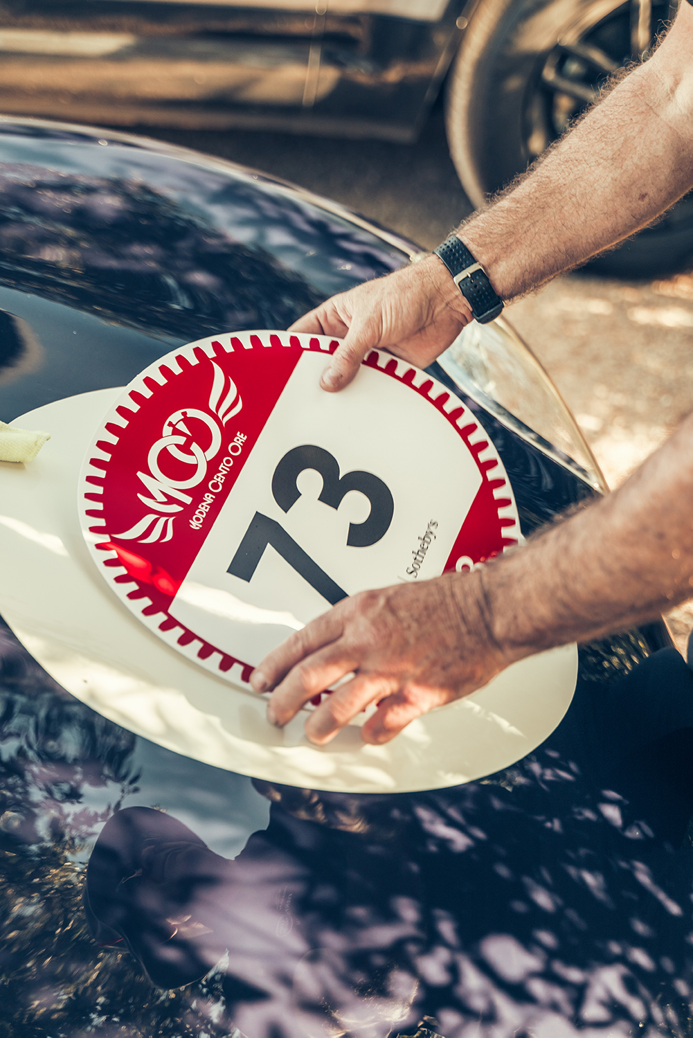 Placing a sticker on a Jaguar D-type at the Modena Cento Ore