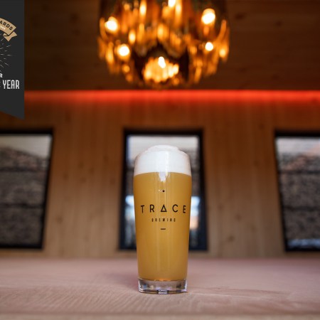 a beer on a wood table under a chandelier