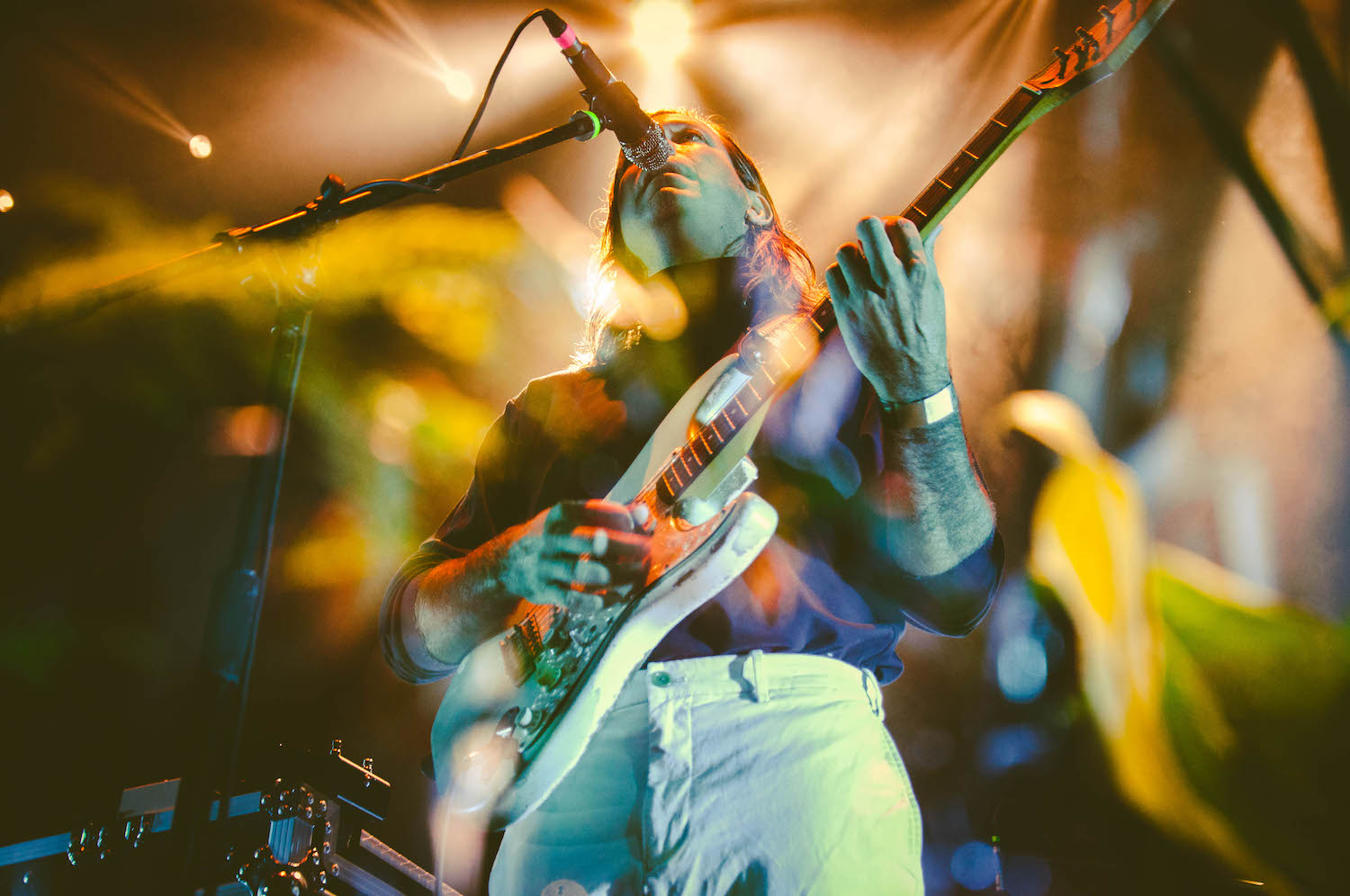 Person performing on a stage with a guitar 