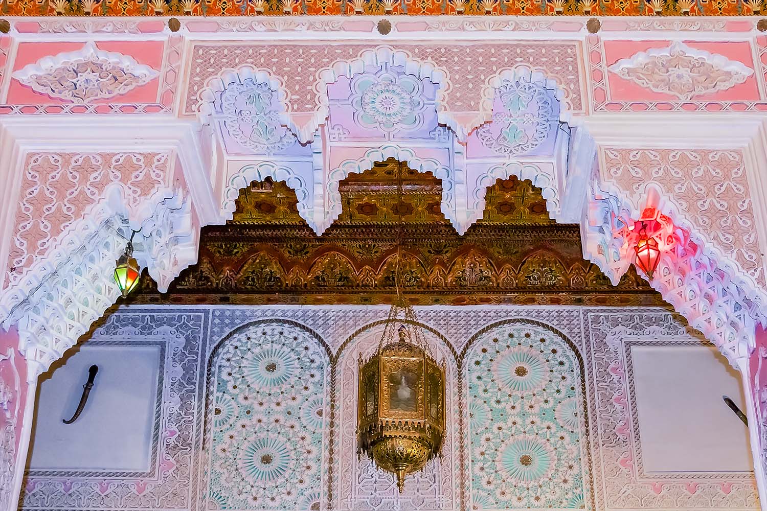 Colorful plaster and cedar arabesque carvings on the ceiling in a Moroccan riad