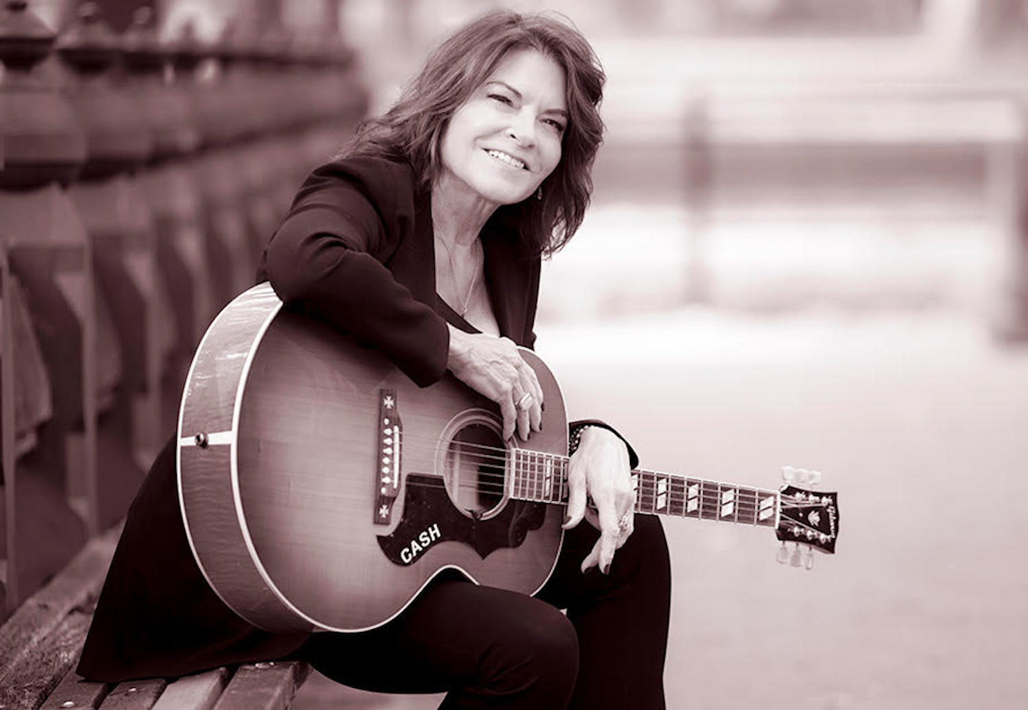 Rosanne Cash posing for photo with guitar